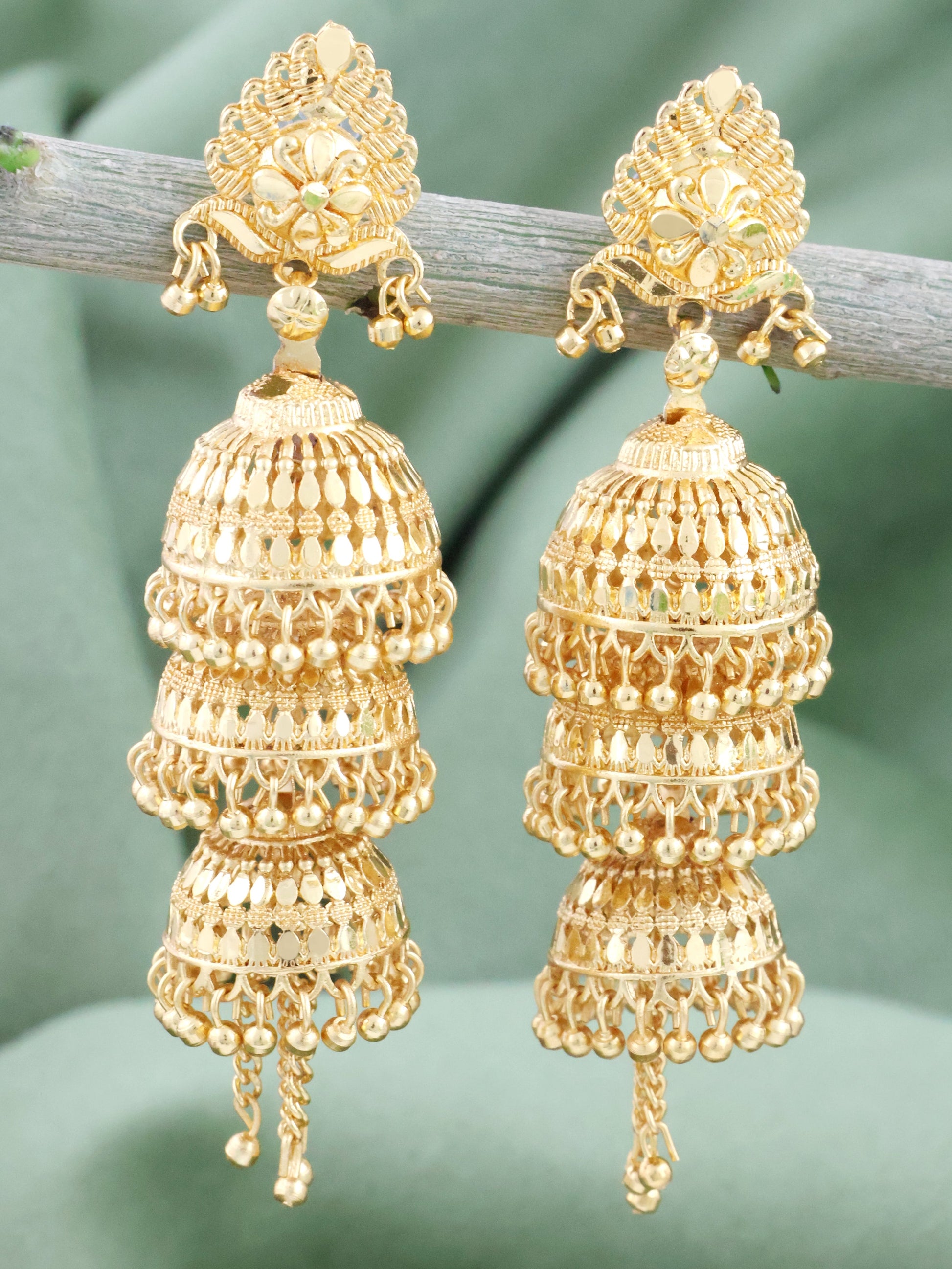 Close-up of a pair of Mekkna Gold Plated Jhumki Earrings. The earrings feature intricate designs with gold plating and traditional Indian jhumki style.
